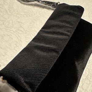 Black velvet bag with magnetic closure.